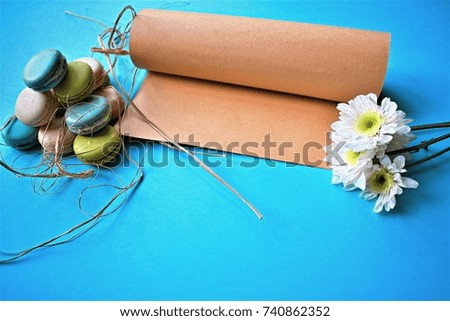 Macaroons cake with note and flower on blue background