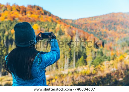 woman taking picture of the autumn yellow carpathian mointains