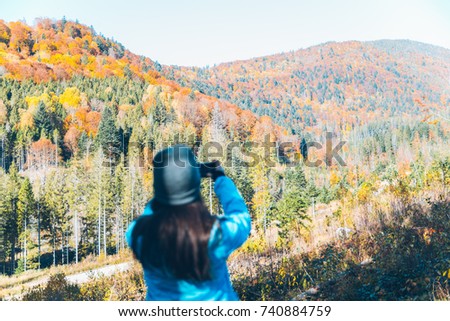 woman taking picture of the autumn yellow carpathian mointains