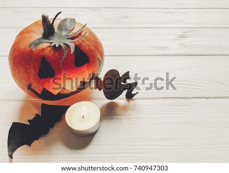 halloween. jack lantern pumpkin with witch ghost bats and spider black decorations on white wooden background. simple cutouts for autumn holiday celebration. seasonal greetings