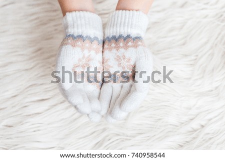 Winter children's hands are white in mittens on a white fur background.Hygge. Hands are holding