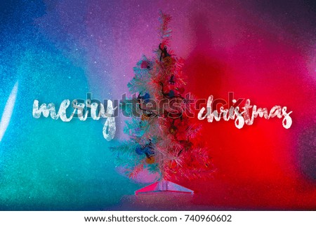 Christmas tree with "Merry Christmas" wording in the light colored spotlights