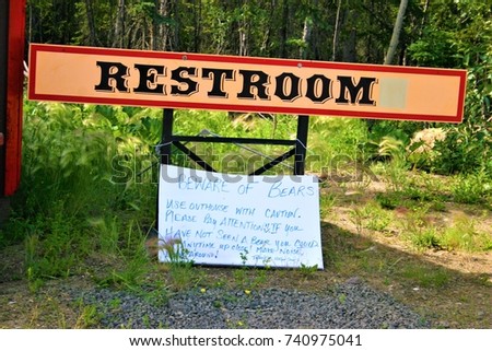 A restroom with a watch out for bear sign