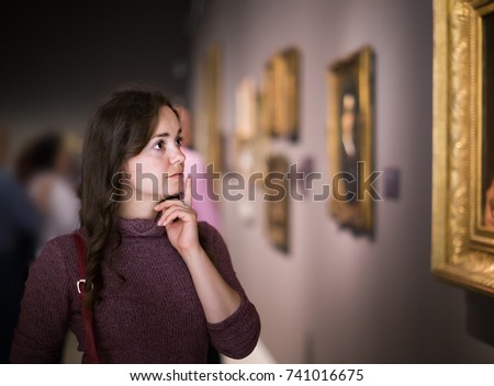 Woman watching at art collection exhibition in museum
