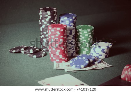 Stack of casino chips and dollar bills on the poker table. Vintage filtered photo