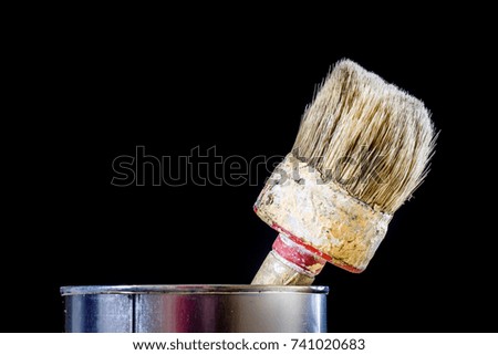 Old paintbrushes for paint, Cans of paint on wooden table. Painting workshop. Black background