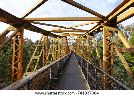Empty pedestrian walkway on a yellow steel bridge. Fairfield Pipe Bridge, Melbourne, Australia