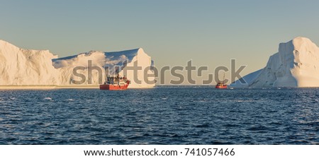 Greenland, Disko Bay. Tourists take pictures of the iceberg. Source of icebergs is by the Jakobshavn glacier. This is a consequence of the phenomenon of global warming and catastrophic thawing of ice 