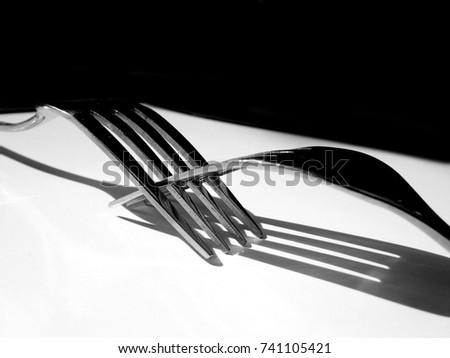 Fork background / A fork in cutlery or kitchenware is a tool consisting of a handle with several narrow tines on one end. The usually metal utensil is used to lift food to the mouth