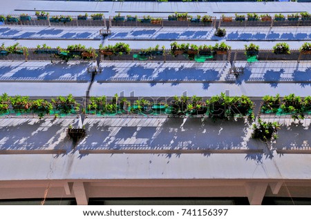 Green skyscraper building with plants growing on the facade.