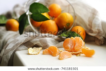  Mandarins in a glass bowl and warm scarf on the windowsill. White background.