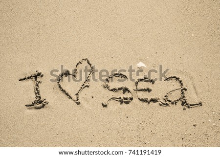 The inscription on the sand near the sea and the waves - I love sea. Background.