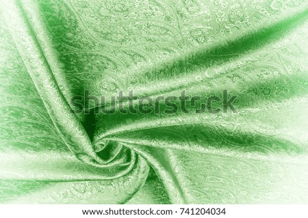 Background texture, pattern. Paisley Silk green Jacquard is a complex woven glossy fabric with a woven design.