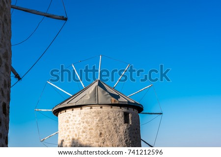 Close detailed view of ancient stone windmill on clean blue sky background in Alacati town, a popular destination for traveling and holiday in Izmir,Turkey.Copy space for editing.