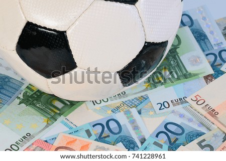 beautiful leather soccer ball lies on a pile of paper euro bills 
