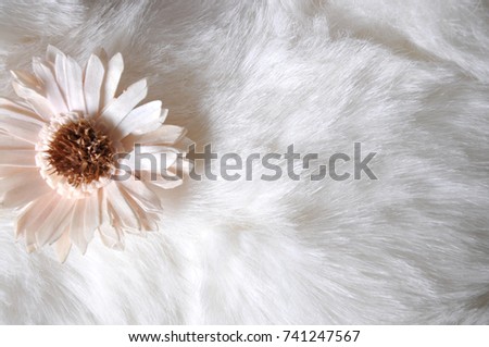 Little paper flower on white puffy fabric background