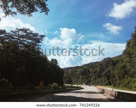 Highway road with sun shine line on the cloudy blue sky and nature beside. Copy space wallpaper