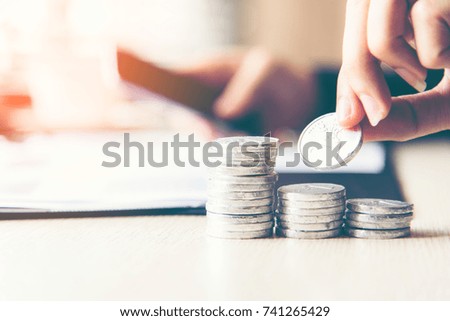 Businessman hand putting stack of coin money cover growing plant for the investment financial report.  Investment concept
