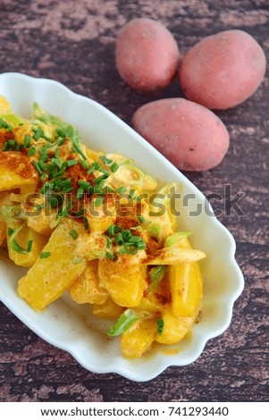 Boiled potato wedges with leek, mayonnaise, paprika powder and chives