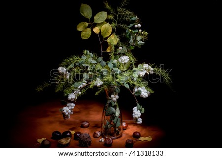 Autumn still life. Bouquet in a vase on a black background