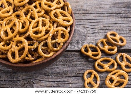 Pretzels in bowl on wooden background . Photo of snack