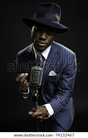 Black man with blue striped suit and blue hat singing. Jazz musician. Night club. Cotton club. New Orleans. Royalty-Free Stock Photo #74132467
