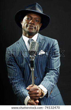 Black man with blue striped suit and blue hat singing. Jazz musician. Night club. Cotton club. New Orleans.