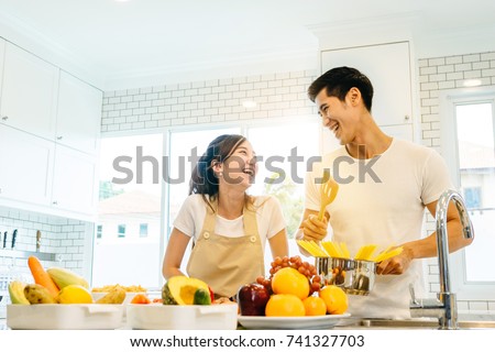Asian teen couple are helping to make dinner. And bakery together happily. On Valentine's Day in their home. Royalty-Free Stock Photo #741327703