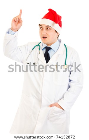 Surprised medical doctor in Santa hat with rised finger isolated on white. Idea gesture