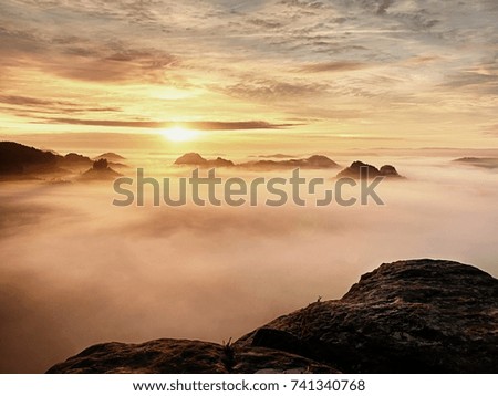 Autumn early morning view over sandstone rocks to fall valley of Saxony Switzerland. Sandstone peaks and hills increased from misty background. 