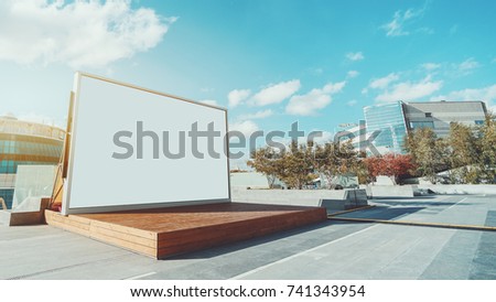 Horizontal blank information banner standing near wooden stage, empty mock-up of poster in urban settings, white clean billboard with copy space for logo, text or other advertising on bright day