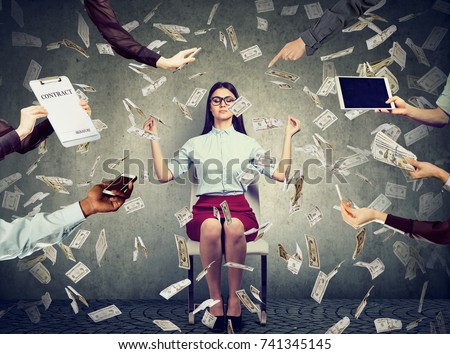 Young business woman is meditating to relieve stress of busy corporate life under money rain   Royalty-Free Stock Photo #741345145