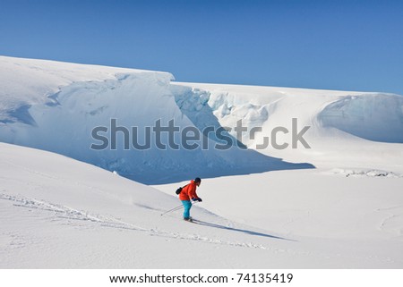 Man moves on skis. Glacier in background. Antarctica