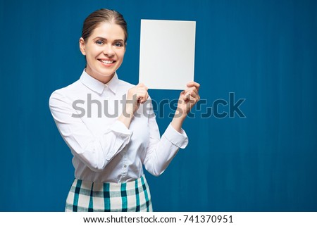 smiling woman wearing white shirt holding sign board. blue wall back.