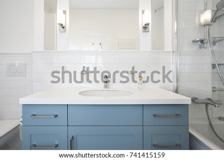 Classical white bathroom interior with blue cabinet