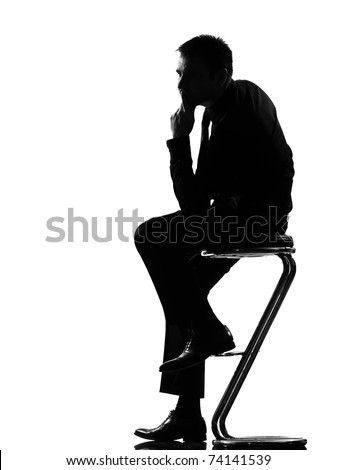 silhouette caucasian business man thinking pensive sititting on foot stool full length on studio isolated white background