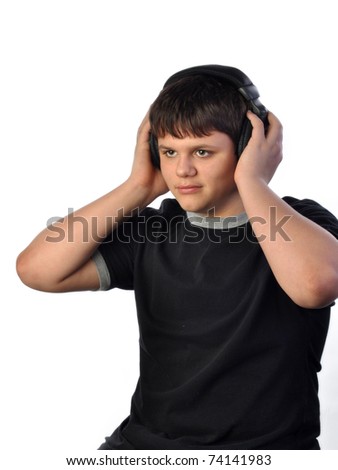 Teenage boy with headset listing to music on white set