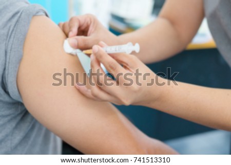 Blurry Background of Nurse are vaccinations to patient. To prevent diseases that are prevalent. closed-up of hand with vaccine shot.
