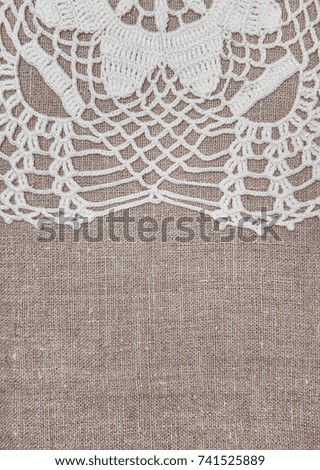 Vintage lace fabric border on the old burlap textile background