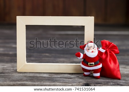 Christmas concept, Santa Claus with red bag over empty wood frame 
