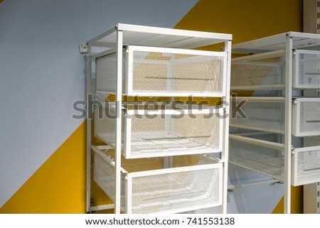 White metal drawer against white and yellow wall.