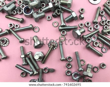 The selective focus of screw, washers, bolt and nuts over the plain background. 