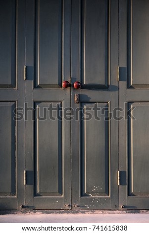 Beautiful of old wooden blue door at entrance to house, texture of blue door with red door knob and sunshine lighting