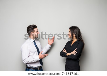Smiling businesswoman and businessman are conversing against grey Royalty-Free Stock Photo #741617161