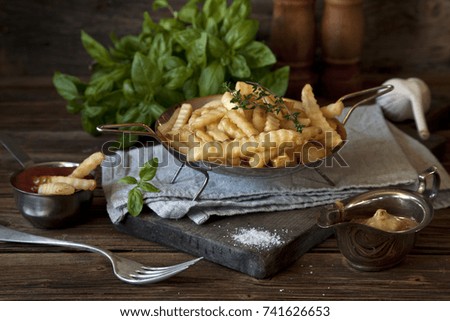 French fries, tomato ketchup and mustard on rustic wooden background. Selective focus, close up, shallow depth of field