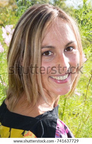 Portrait of a beautiful young woman in the rays of the setting sun in a blooming spring garden