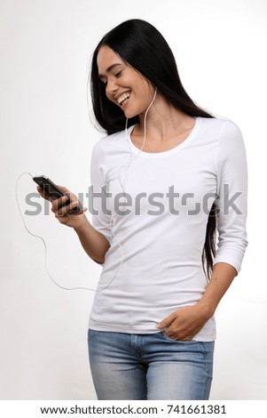 Beautiful woman listens to music with smart phone and earphones