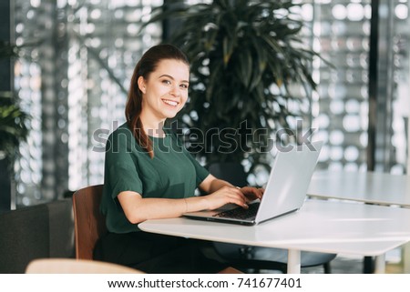 beautiful business lady at work with a laptop and phone sitting in the office