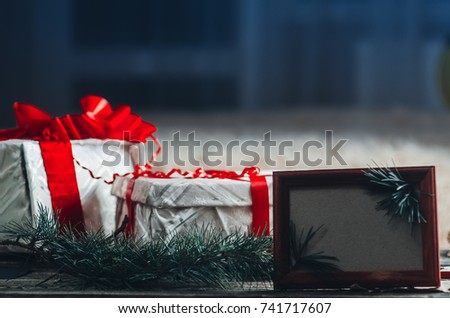 On wooden table are packing boxes with gifts, next to the frame and they are bumps