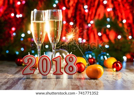 The New Year 2018. Glasses with champagne. Christmas. oranges tangerines Background. Lights garland.